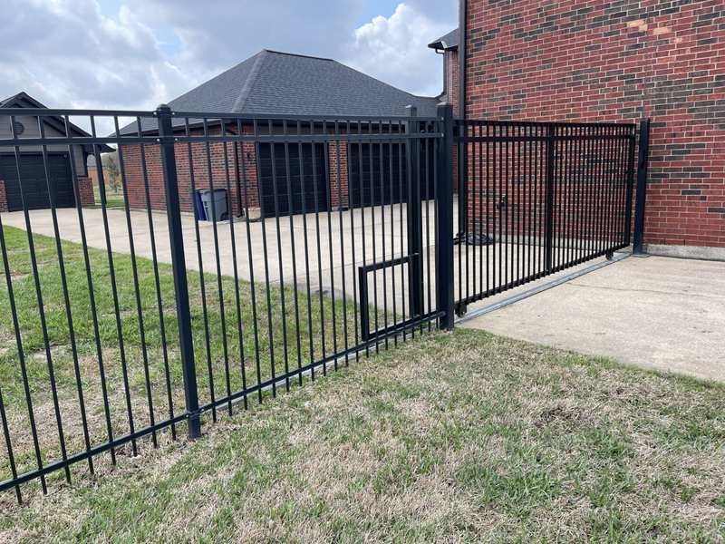 Black ornamental iron fence with gate installed along a residential driveway in Boise, ID